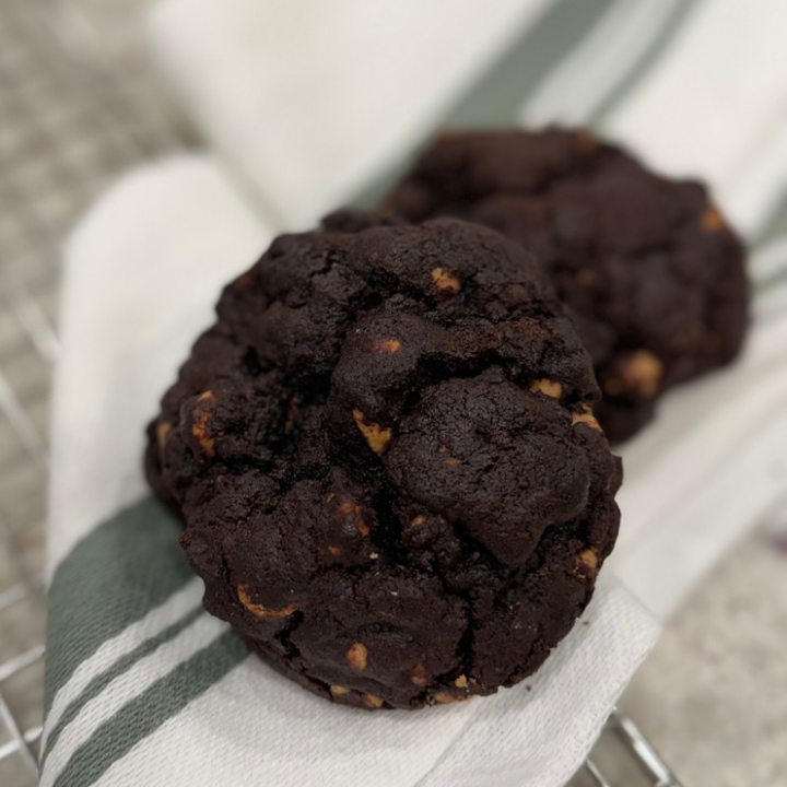Baker holding a tray of freshly baked artisan cookies